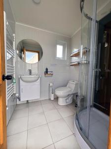 een badkamer met een toilet, een wastafel en een douche bij Chilenativo Riverside Camp in Torres del Paine