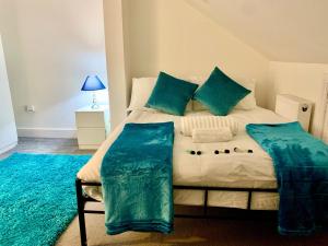 a bedroom with a large bed with blue pillows at Sandra Stay in London