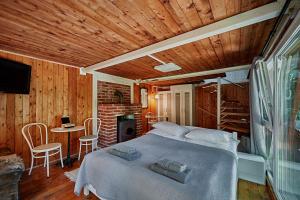 a bedroom with a bed and a table with chairs at Olive Tree Forest Cabin Original in Kismaros