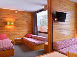 a room with two beds and a flat screen tv at Studio Plagne Bellecôte, 1 pièce, 4 personnes - FR-1-181-2333 in La Plagne Tarentaise