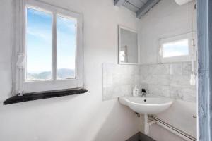 a white bathroom with a sink and a window at AFFRESCATO - Palazzo Ravaschieri in Bracelli +40 photos
