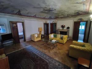 uma sala de estar com mobiliário amarelo e um tecto em caixote em AFFRESCATO - Palazzo Ravaschieri em Bracelli