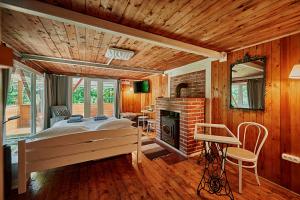 Olive Tree Forest Cabin Original في Kismaros: غرفة نوم بسرير ومدفأة