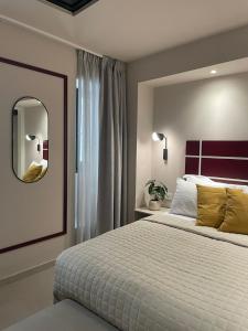 a bedroom with a large bed and a mirror at Living Yard Thissio in Athens