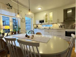 kuchnia ze stołem i krzesłami oraz kuchnia z białymi szafkami w obiekcie Nice semi-detached house in central Landvetter w mieście Landvetter