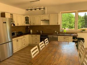 Una cocina con gabinetes blancos y una mesa de madera. en Siedlisko Wierchy, en Wieściszowice 10 fotos más