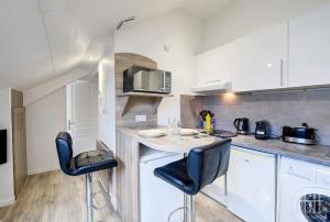 eine Küche mit einem kleinen Tisch und 2 Stühlen in der Unterkunft La Traversière 7 / Proche Gare in Tours