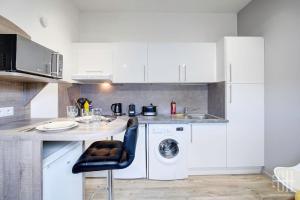 eine weiße Küche mit Spüle und Geschirrspüler in der Unterkunft La Traversière 7 / Proche Gare in Tours