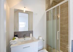 ein weißes Badezimmer mit Waschbecken und Dusche in der Unterkunft La Traversière 7 / Proche Gare in Tours