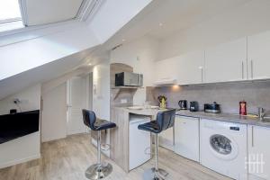 eine Küche mit einer Theke und 2 Hockern in der Unterkunft La Traversière 7 / Proche Gare in Tours + 13 Fotos