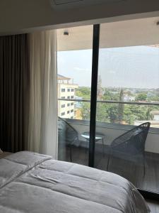 a bedroom with a bed and a large window at Solaris Premium Luxury Living in Accra