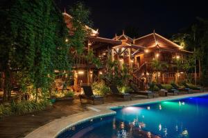 a house with a swimming pool at night at Srey Krob Leak Resort in Battambang