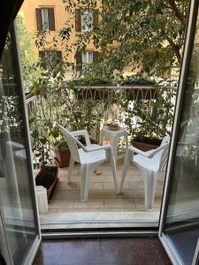 two white chairs and a table on a patio at Spazioso appartamento 10 min a piedi dal Vaticano e metro in Rome