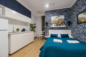 a bedroom with a blue bed and a kitchen at Stadion Narodowy Warszawa UNIT ApartmentMini noclegi Super lokalizacja przy Metro MiniStudio with private banthroom in Warsaw