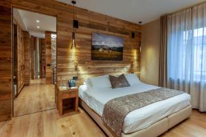 sypialnia z łóżkiem i drewnianą ścianą w obiekcie Asiago Sporting Hotel & Spa w mieście Asiago