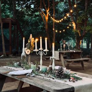 una mesa con velas en ella con un hombre sentado en ella en Cabin Home อยู่ป่า wild and free, en Koh Larn