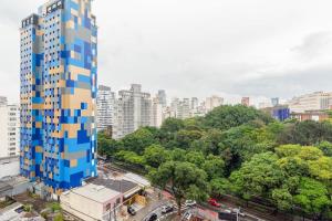 a tall blue and yellow building in a city at BHomy Melo in Sao Paulo