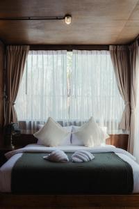 a bedroom with a large bed with a window at Cabin Home อยู่ป่า wild and free in Ko Larn
