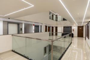 戈尔哈布尔The Living Hub Business Hotel, Kolhapur的大楼内有玻璃楼梯的空走廊