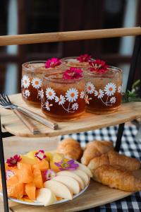 a plate of food on a wooden shelf with jars of honey at Cabin Home อยู่ป่า wild and free in Ko Larn