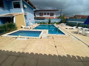 - une piscine avec des chaises et une maison dans l'établissement Casa em condomínio fechado Amaralina, à Porto Seguro
