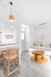 een witte woonkamer met een tafel en een bank bij August Mykonos in Mykonos-stad