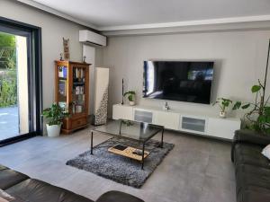 uma sala de estar com uma televisão grande e um sofá em Villa grande piscine 5000m² 5 chambres, paisible nature em Peynier