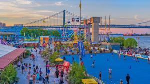 a crowd of people at an amusement park with a ferris wheel at Thena Hotel - Cozy Studio in Philadelphia