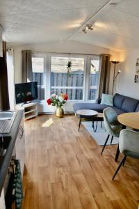a living room with a blue couch and a table at Chalet 27 in Zandvoort