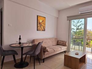 Stylish Apt Kato Paphos Close to Beach & Vibrant Harbor Life في بافوس: غرفة معيشة مع أريكة وطاولة