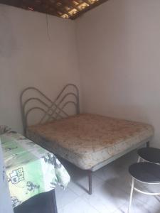 uma cama sentada num canto de um quarto em Casa de Veraneio Praia do Porto em Pôrto das Cabras