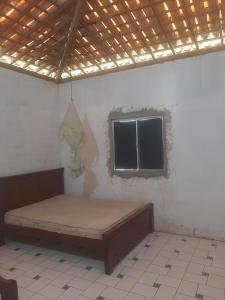 uma cama num quarto com uma janela em Casa de Veraneio Praia do Porto em Pôrto das Cabras