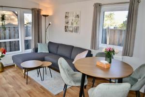 a living room with a couch and a table and chairs at Chalet 27 in Zandvoort +15 photos