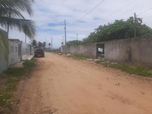 un chemin de terre avec une voiture garée sur le côté dans l'établissement Casa de Veraneio Praia do Porto, à Pôrto das Cabras