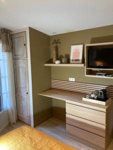 a living room with a tv and a shelf at La Vagabonde in Saint-Tropez