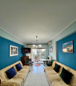 a living room with blue walls and a couch at Vivian’s apartment in Chalkida