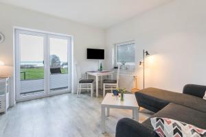 a living room with a couch and a table at Ferienhaus Ostseeblick in Munkbrarup