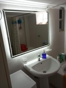 a bathroom with a sink and a mirror at Vivian’s apartment in Chalkida