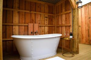 uma banheira num quarto com paredes de madeira em Retreat East em Ipswich