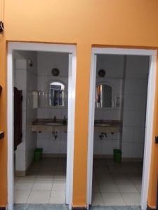 łazienka z 2 umywalkami i 2 lustrami w obiekcie Hostal Las Carretas w mieście San Miguel de Tucumán
