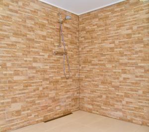 ein Bad mit einer Dusche in einer Ziegelwand in der Unterkunft Rio Grande Luxury Western Rooms in Terschuur