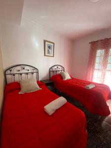 2 camas en una habitación con mantas rojas en Casa Rural Balcones de Setenil, en Setenil