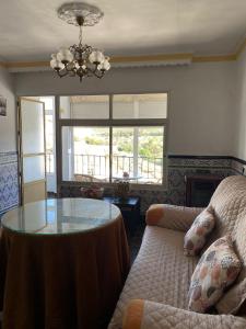 sala de estar con mesa de cristal y sofá en Casa Rural Balcones de Setenil, en Setenil