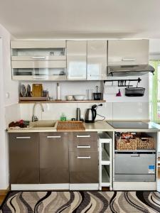 a kitchen with white cabinets and stainless steel appliances at Pokoje na Zaciszu - Metro Zacisze in Warsaw