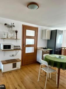 a room with a table and a kitchen with a door at Pokoje na Zaciszu - Metro Zacisze in Warsaw