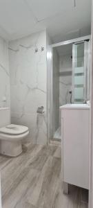 y baño blanco con aseo y ducha. en Style Apartments Cabanyal Marina Beach, en Valencia