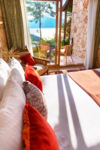a bed in a room with a view of the ocean at Fidanka Hotel in Kalkan
