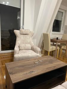 uma sala de estar com um sofá e uma mesa com copos de vinho em Apartman Comfort Beograd em Belgrado