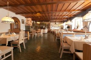 un ristorante con soffitti e tavoli in legno e sedie di Landgasthof Postwirt a Lam