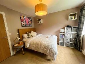 a small bedroom with a bed and a lamp at Riverside one bedroom flat in Bridge of Allan